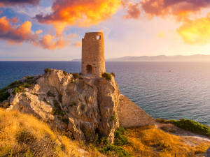 Ein Turm am Meer auf Sardinien im Sonnenuntergang