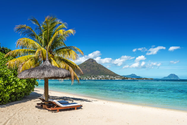 Palme mit Strohdachliege an weißem Sandstrand auf der Île aux Cerfs, Mauritius, mit Blick auf den Indischen Ozean. | Gebeco