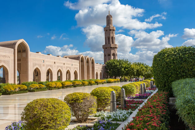 Große Sultan Qabus Moschee in Muskat mit bunten Sträuchern im Vordergrund – Oman Architektur | Gebeco