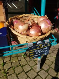 Ein Korb mit rosafarbenen Zwiebeln in Roscoff in der Bretagne, Frankreich I Gebeco