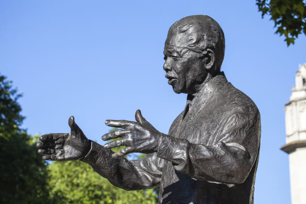 Bronzestatue von Nelson Mandela mit ausgestreckten Armen vor blauem Himmel in Johannesburg, Südafrika. | Gebeco