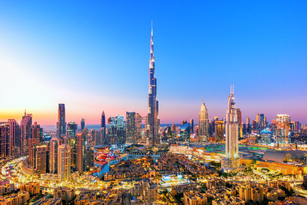Abendliche Skyline von Dubai mit Burj Khalifa im Zentrum, umgeben von beleuchteten Wolkenkratzern. | Gebeco 