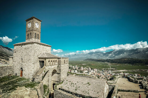 Historische Burg von Gjirokastra in Albanien mit Uhrturm und Blick über die Stadt und umliegende Berge. | Gebeco