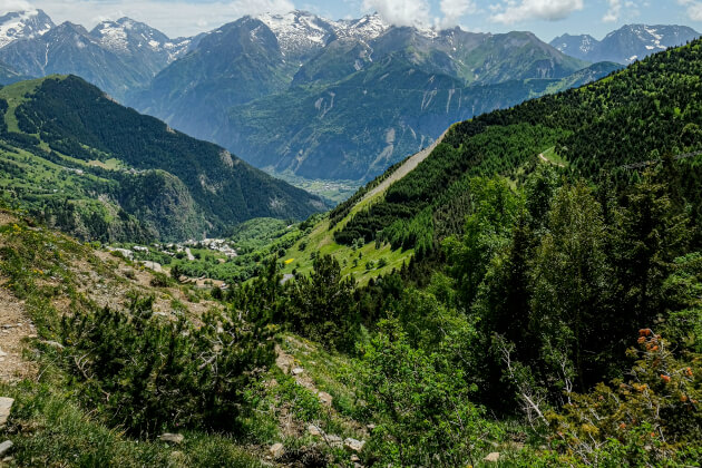 Blick in ein grünes Bergtal der albanischen Alpen mit schneebedeckten Gipfeln. | Gebeco