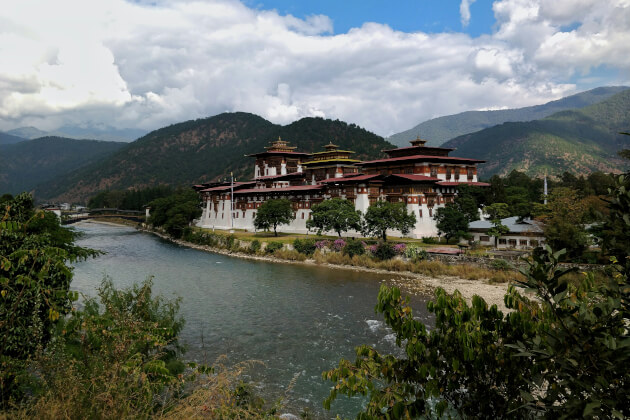 Bhutan Punakha Dzong am Flussufer mit Himalaya-Bergkulisse im Hintergrund. | Gebeco