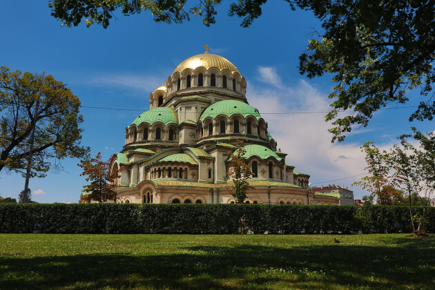 Alexander-Newski-Kathedrale in Sofia mit goldener Kuppel vor blauem Himmel, umgeben von Grünflächen. | Gebeco