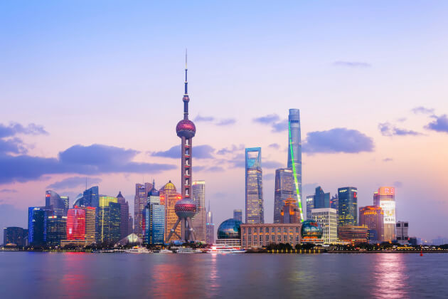 Skyline von Shanghai bei Sonnenuntergang mit Blick auf den Oriental Pearl Tower und moderne Hochhäuser am Ufer des Huangpu-Flusses. | Gebeco
