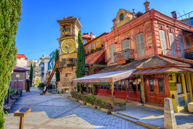 Uhrturm des Puppentheaters in der Altstadt von Tiflis mit farbenfrohen Häuserfassaden und Kopfsteinpflastergasse. | Gebeco