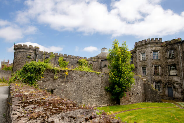 Historisches Gefängnis Cork City Gaol mit grauen Steinmauern und Rundtürmen im Sonnenschein. | Gebeco