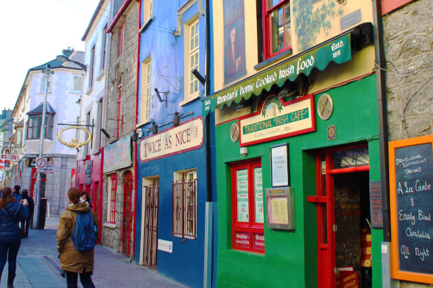 Bunte Ladenfassaden und Fußgänger in der Altstadt von Galway mit traditionellem Irish Café. | Gebeco