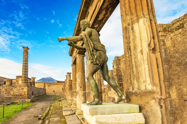 Statue in den Ruinen von Pompeji mit Blick auf den Vesuv im Hintergrund. | Gebeco