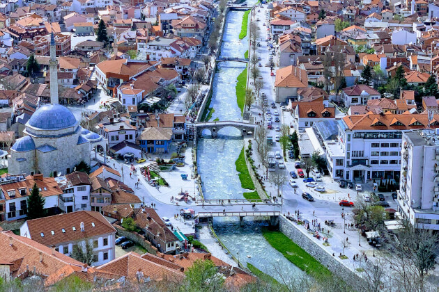 Altstadt von Prizren mit Fluss, Steinbrücken, Moschee und roten Ziegeldächern in lebendiger Stadtlandschaft. | Gebeco