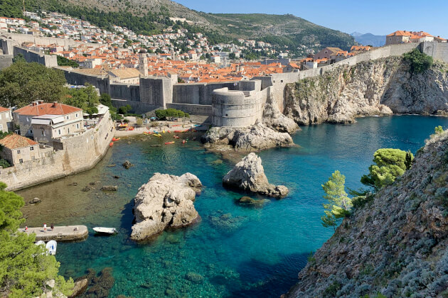 Blick auf die Altstadt von Dubrovnik mit Stadtmauer, Felsen und türkisfarbenem Meer in der Adria. | Gebeco