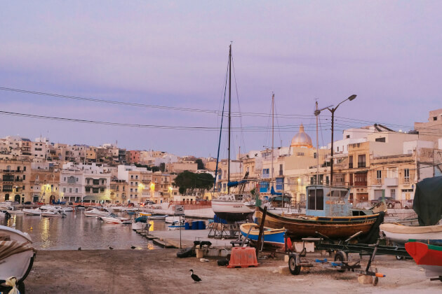 Fischerboote im Hafen von Cospicua bei Sonnenuntergang mit historischen Häusern im Hintergrund. | Gebeco 