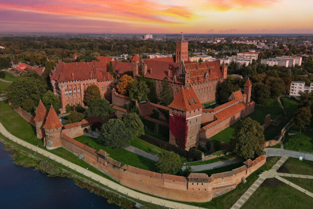 Luftaufnahme der Marienburg in Polen bei Sonnenuntergang – größte Backsteinburg Europas. | Gebeco