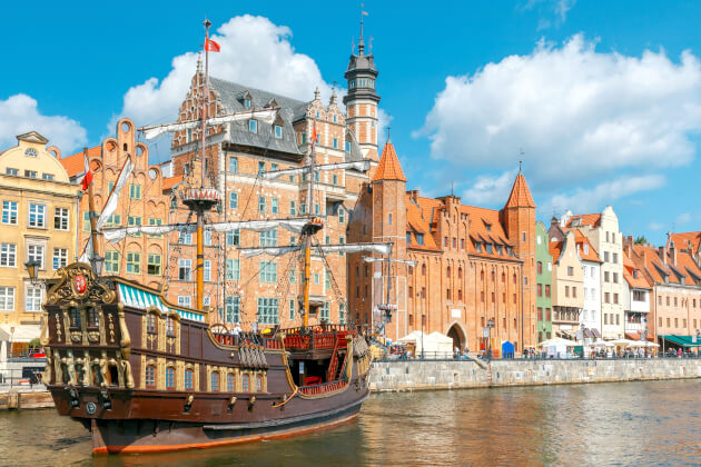 Historische Kogge im Hafen von Danzig vor der Kulisse der Altstadt und der Speichergebäude. | Gebeco