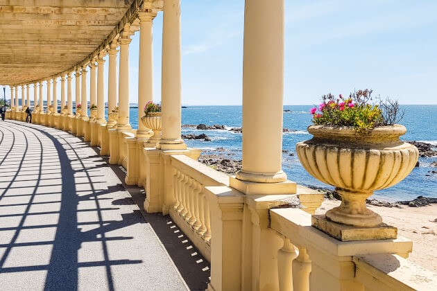 Elegante Pergola-Promenade an der Atlantikküste von Porto mit klassischer Säulenarchitektur und Meerblick bei Sonnenschein. | Gebeco