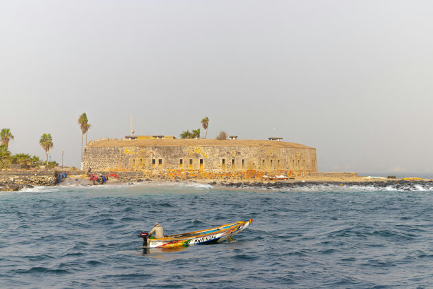 Historisches Fort d’Estrées auf der Insel Gorée im Senegal mit traditionellem Fischerboot im Vordergrund. | Gebeco