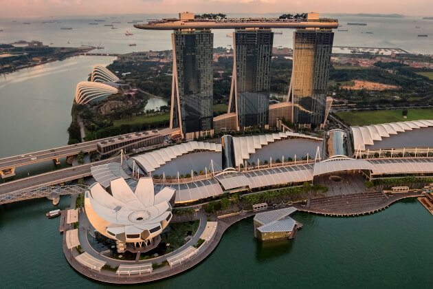 Marina Bay Sands mit SkyPark, ArtScience Museum und Uferpromenade in Singapur bei Sonnenuntergang. | Gebeco