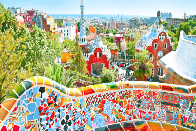 Bunte Mosaikbänke und märchenhafte Gebäude im Park Güell in Barcelona mit Blick über die Stadt. | Gebeco