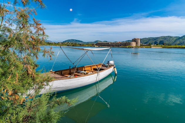 Boot am Vivari-Kanal mit Blick auf das Dreiecksschloss von Butrint in Albanien