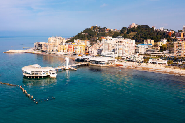 Uferpromenade und Pier von Durrës, Albanien, mit Sandstrand und moderner Skyline