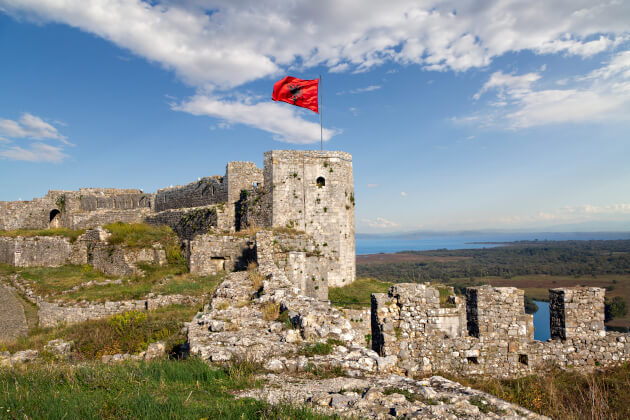 Ruinen der Festung Rozafa in Shkodra mit wehender albanischer Flagge und Blick auf die Landschaft