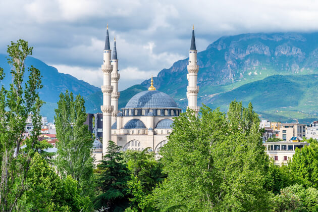 Große Moschee von Tirana mit Minaretten vor grüner Berglandschaft