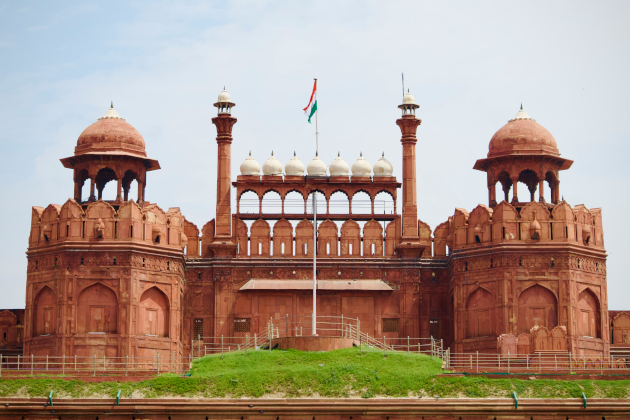 Frontansicht des Roten Forts in Delhi mit Nationalflagge, beeindruckende rote Sandsteinfassade. | Gebeco
