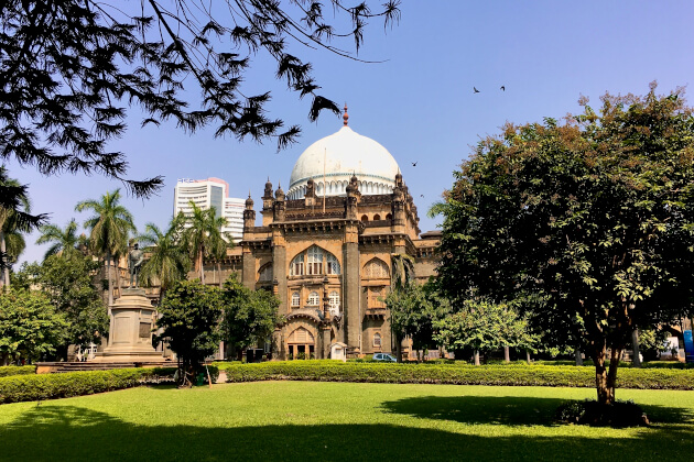 Historisches Museum in Mumbai mit großer weißer Kuppel, umgeben von Palmen und grüner Gartenanlage. | Gebeco