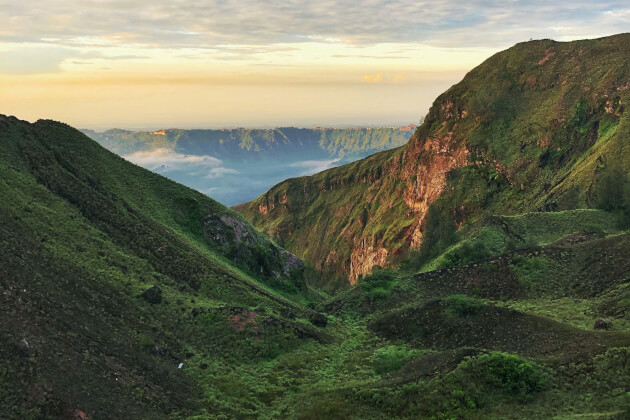 Tief eingeschnittenes Tal mit grünem Vulkangestein und Sonnenaufgang auf Bali, Indonesien. | Gebeco