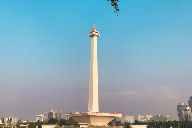 Das 132 Meter hohe Nationalmonument Monas mit goldener Flamme in Jakarta vor blauem Himmel. | Gebeco