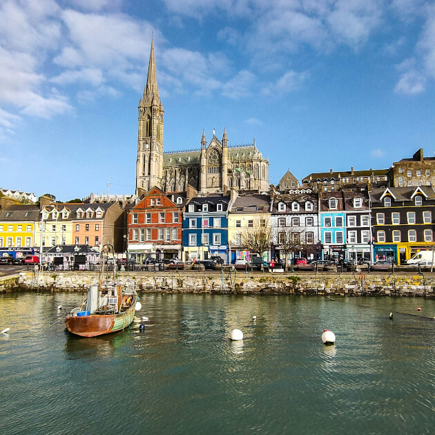Blick auf den Hafen von Cobh mit bunten Häusern und der imposanten St. Colman’s Cathedral. | Gebeco