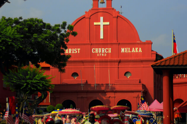 Frontansicht der roten Christ Church in Melaka mit belebter Straße im Vordergrund. | Gebeco