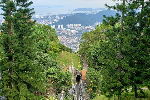 Blick vom Penang Hill auf grüne Hügel und die Skyline von George Town mit der Standseilbahn im Vordergrund. | Gebeco