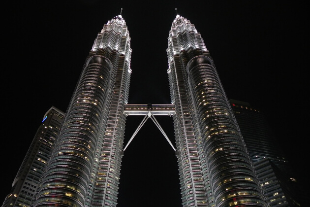 Die beleuchteten Petronas Towers ragen nachts imposant in den Himmel über Kuala Lumpur. | Gebeco