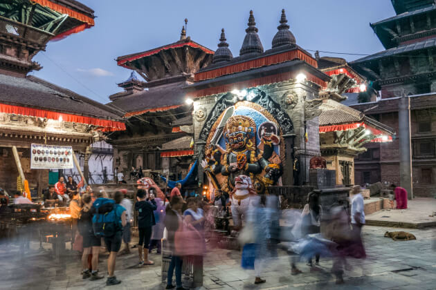 Menschenmengen vor einem Tempel mit der Statue des Kal Bhairav in Kathmandu, Nepal. | Gebeco