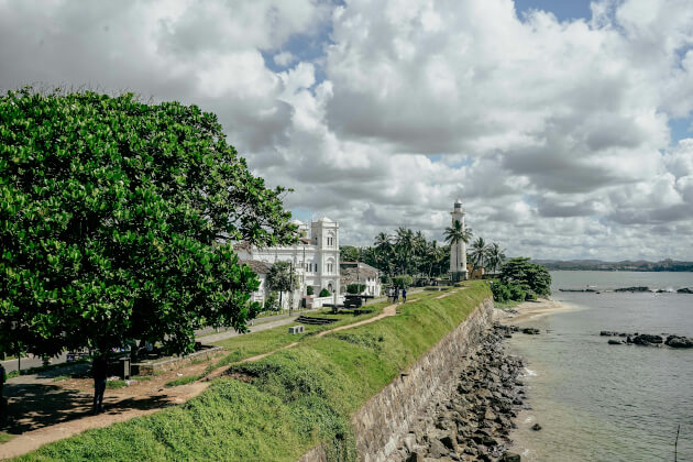 Galle Fort in Sri Lanka mit Blick auf den weißen Leuchtturm, koloniale Gebäude und das Meer unter bewölktem Himmel. | Gebeco