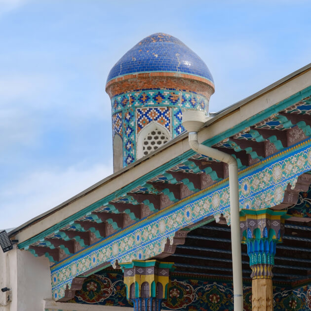 Detailansicht einer farbenfroh dekorierten Moschee mit blauem Kuppeldach und geschnitzten Holzsäulen in Kokand, Usbekistan. | Gebeco