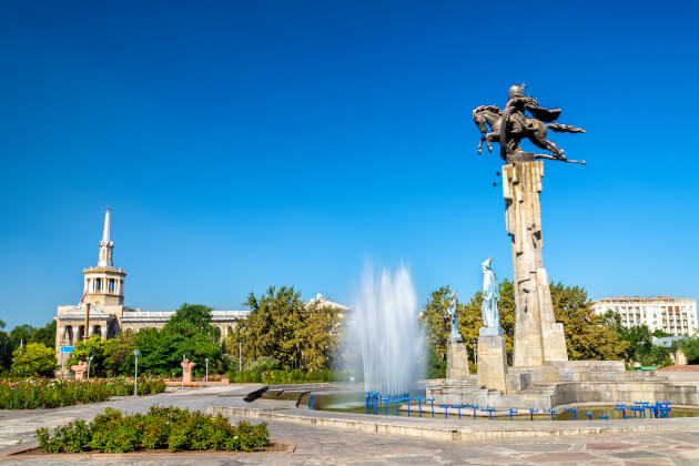 Reiterstatue des Nationalhelden Manas auf dem Ala-Too-Platz in Bischkek mit Brunnen und blauer Himmel. | Gebeco