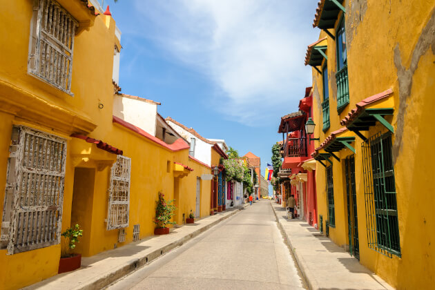 Bunte koloniale Häuserfassaden in einer engen Gasse der Altstadt von Cartagena de Indias in Kolumbien bei Sonnenschein. | Gebeco