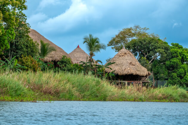 Traditionelle Strohhütten eines Embera-Dorfes am Flussufer im tropischen Regenwald von Panama. | Gebeco