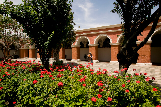 Blühender Klostergarten mit roten Geranien und Säulengängen im Kloster Santa Catalina in Arequipa, Peru. | Gebeco