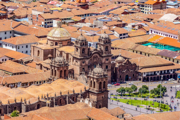 Kathedrale auf der Plaza de Armas von Cusco mit umliegenden Terrakottadächern bei Tageslicht. | Gebeco
