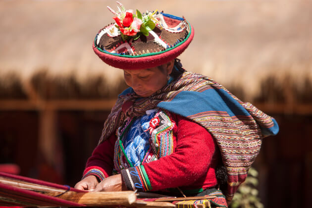 Indigene Quechua-Frau in traditioneller Kleidung beim Weben von Textilien in den peruanischen Anden. | Gebeco