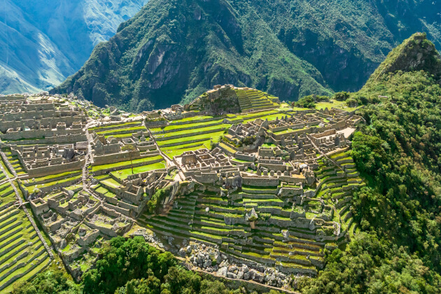 Luftaufnahme der Inka-Ruinen von Machu Picchu mit grünen Terrassenfeldern und umgebenden Anden in Peru. | Gebeco