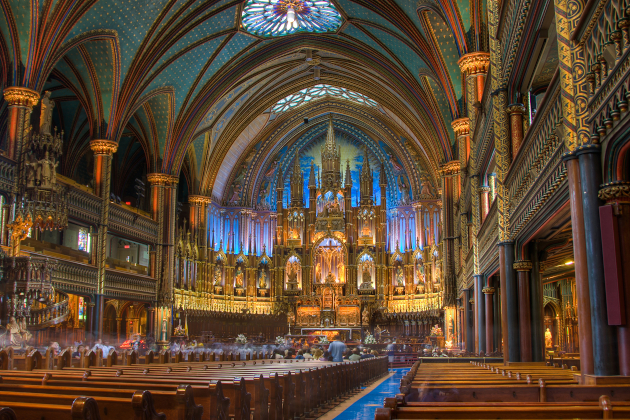 Innenraum der Basilika Notre-Dame in Montreal mit reich verziertem Altar und farbig beleuchtetem Gewölbe