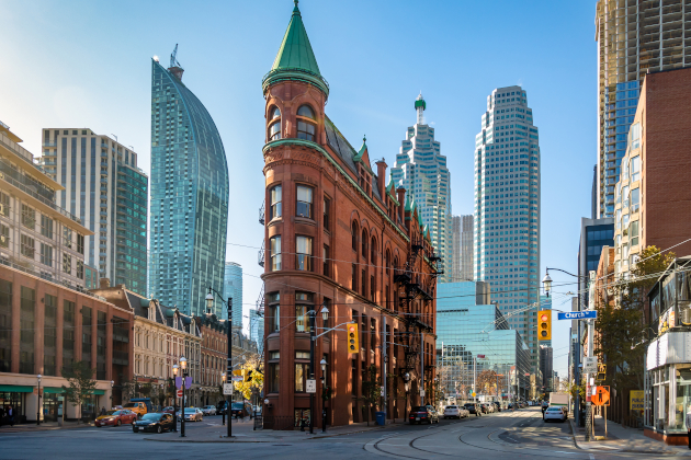 Straßenszene in Toronto mit dem Gooderham Building im Vordergrund und modernen Hochhäusern im Hintergrund