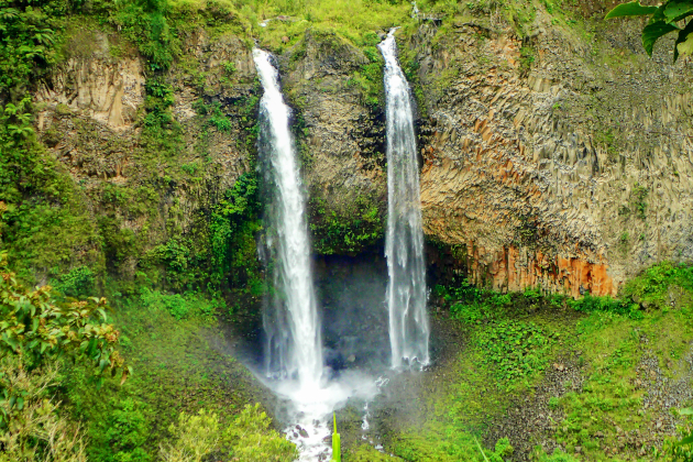 Doppelter Wasserfall bei Baños Ecuador in grüner Schlucht mit Felswänden