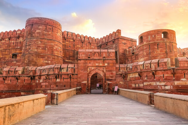  Eingangstor des Agra Fort in Indien, umgeben von roten Sandsteinmauern der imposanten Festung. | Gebeco